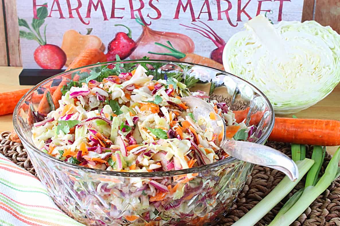 A beautiful glass bowl filled with a colorful coleslaw without mayonnaise. 