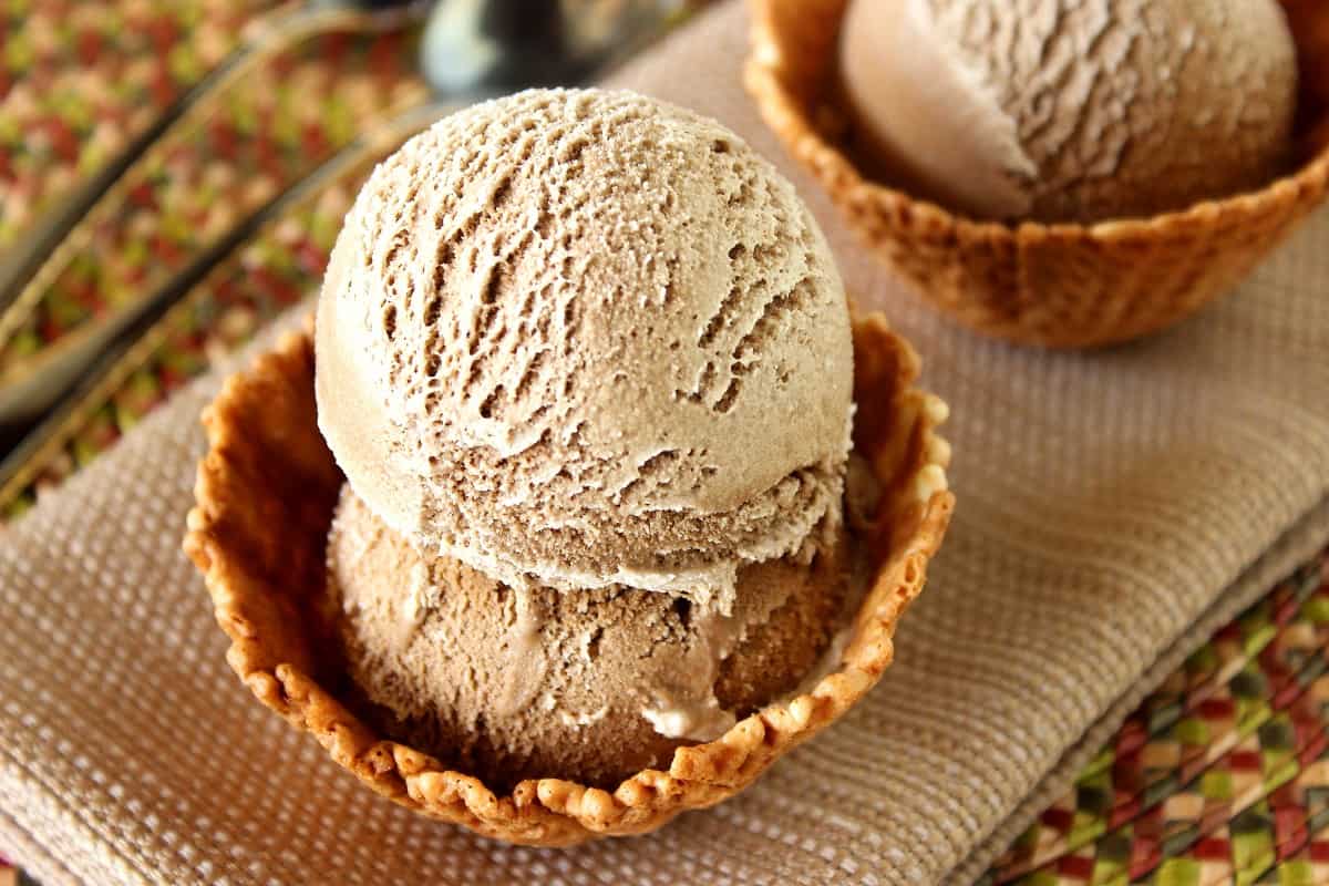 A waffle cone ice cream bowl filled with two scoops of Root Beer Ice Cream.