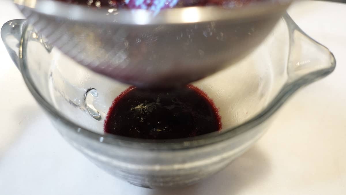 The juice from cooked berries in a glass bowl.