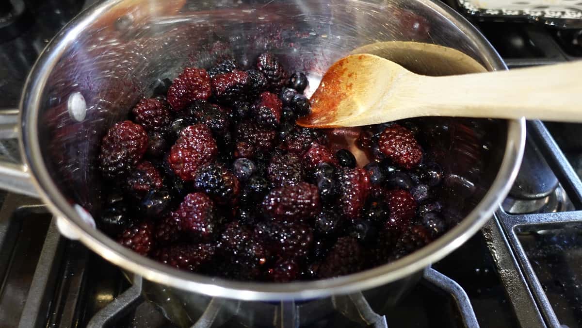 Berries and a wooden spoon in a saucepan.