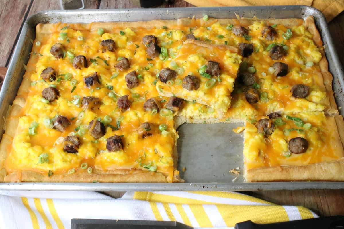 A baking with an Egg Pizza with sausage and cheese on top.