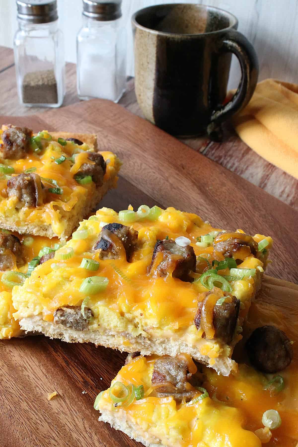 Slices of Egg Pizza on a wooden serving board.