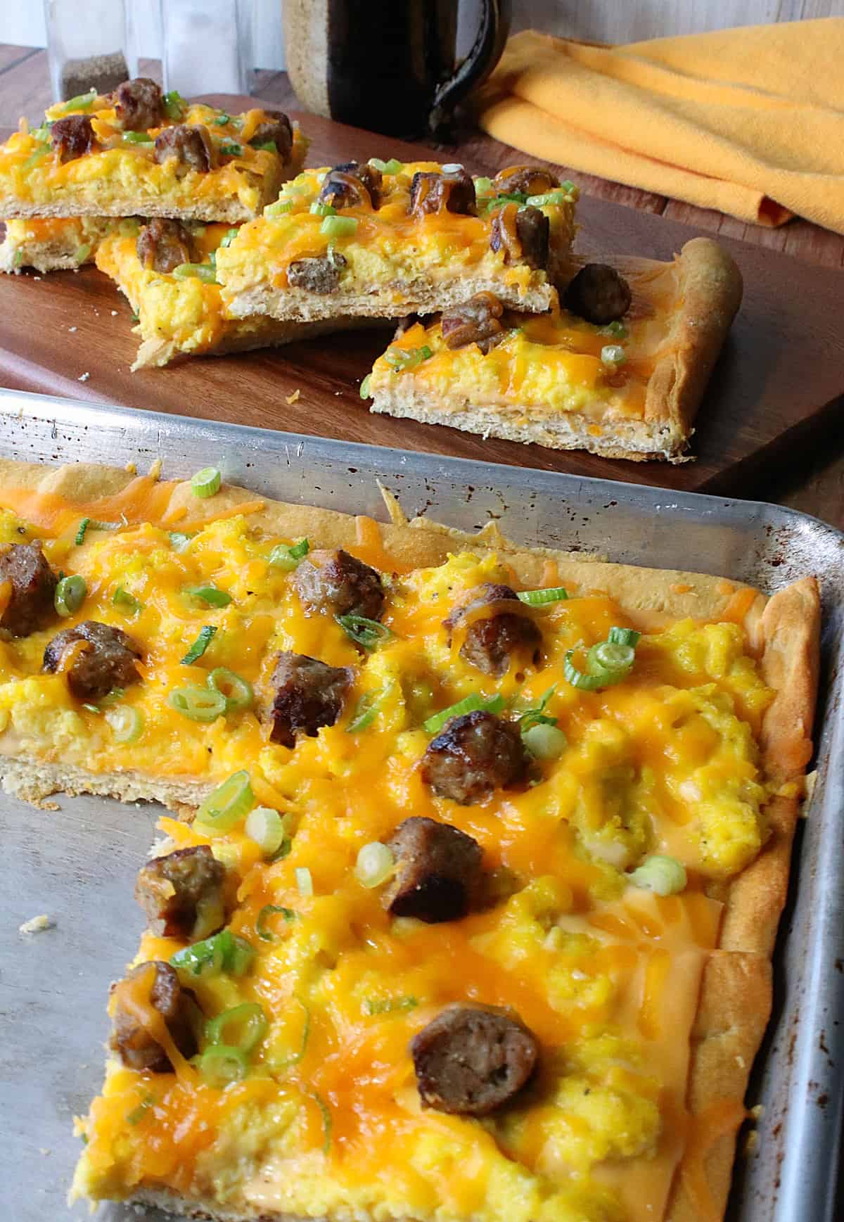 A cheesy Egg Pizza in a baking sheet with scallions and melted cheese.