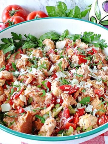 An Italian Panzanella Salad in a large bowl with tomatoes.