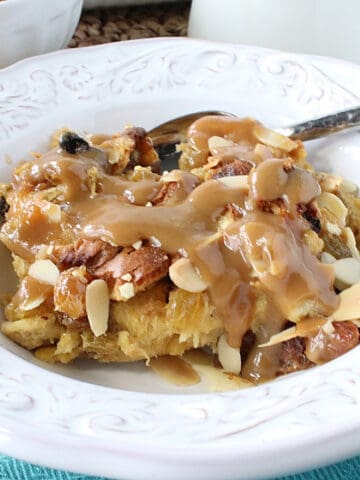 Panettone Bread Pudding with RumChata sauce in a white bowl.