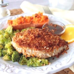 A Coconut Crusted Tuna Steak on a plate with broccoli.