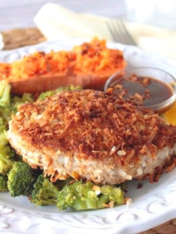 A Coconut Crusted Tuna Steak on a plate with broccoli.