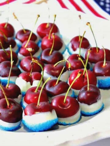 Red, white and blue sugared cherries on a plate.