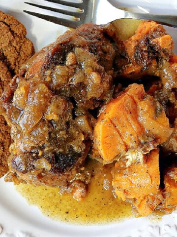 Apple Cider Braised Chicken with sweet potatoes on a plate with gingersnap cookies.