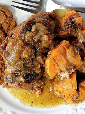 Apple Cider Braised Chicken with sweet potatoes on a plate with gingersnap cookies.