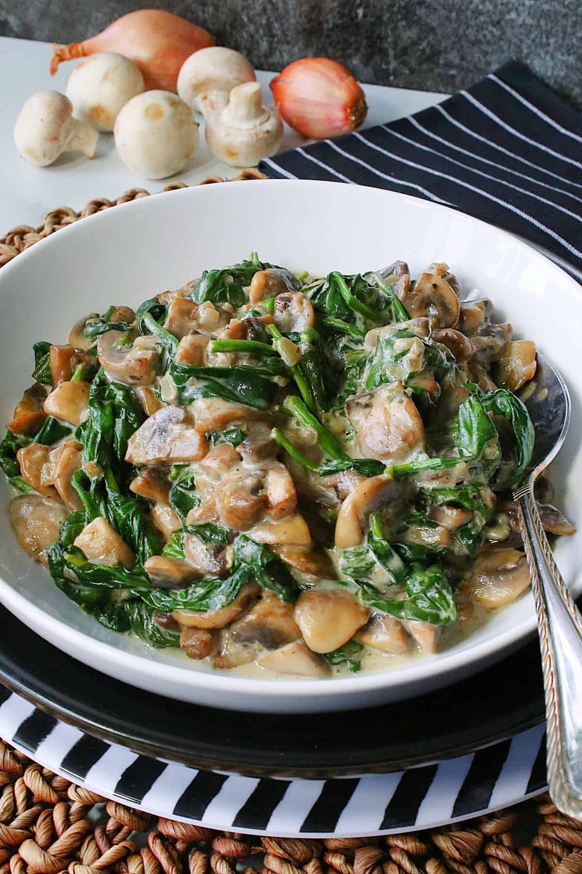 A with bowl filled with Creamy Mushrooms and Spinach with a serving spoon.