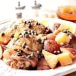 A serving of Slow Cooker Chicken Vesuvio on a plate with capers, potatoes, and chicken.