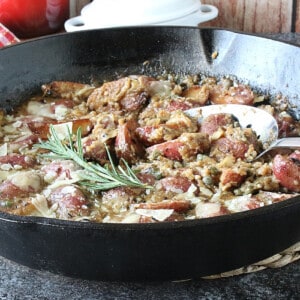 Vesuvio Potatoes and Gravy in a skillet with fresh rosemary.