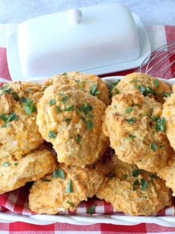 Cheddar Bay Biscuits in a basket with a red and white checked napkin.