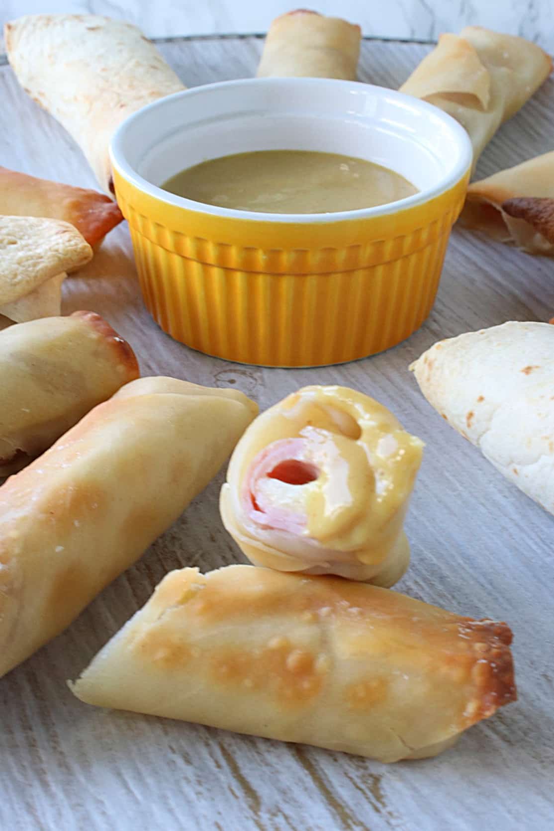 The inside of a Ham and Cheese Eggroll with dipping sauce.