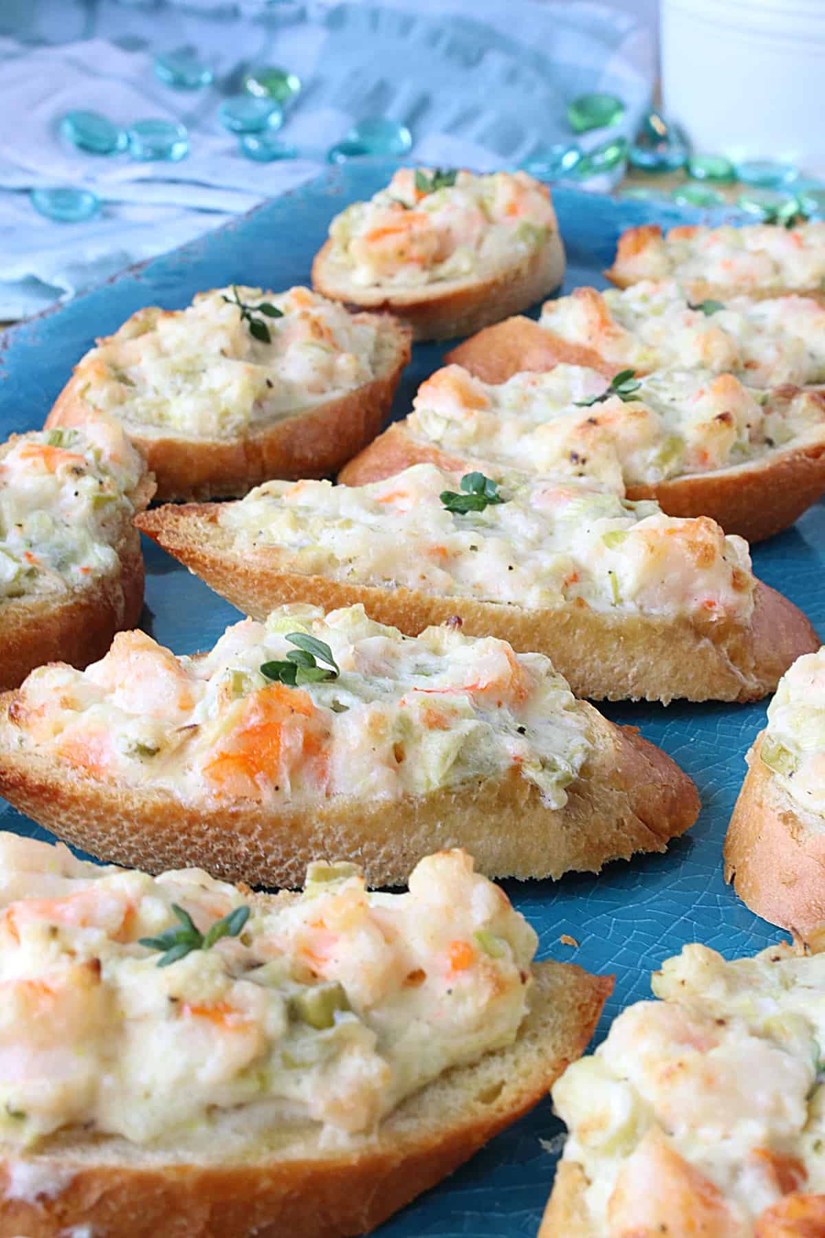 A blue platter with a bunch of Shrimp Rangoon Garlic Toasts all lined up.