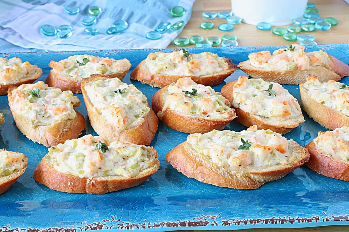 A bright blue platter filled with hot Shrimp Rangoon Garlic Toasts.