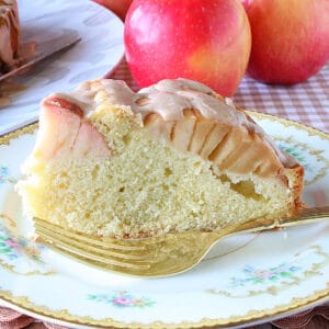 A slice of German Sunken Apple Cake on a pretty plate with a fork.