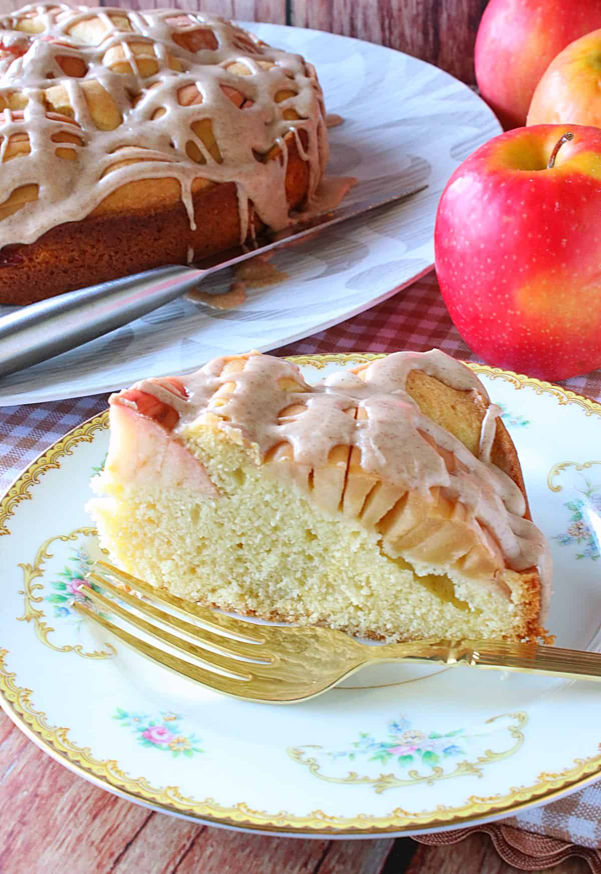 A pretty slice of German Sunken Apple Cake on a plate with a fork.