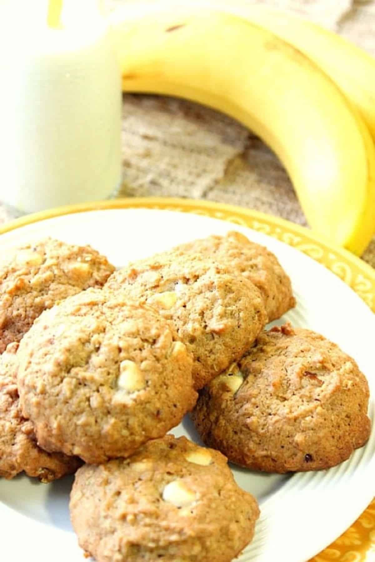 A plate filled with Banana Walnut Cookies and a few ripe bananas in the background.