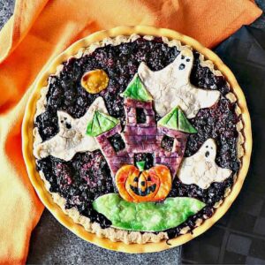 A Boo Berry Pie with a haunted house and ghosts painted pie crust.