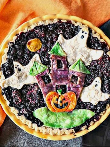 A Boo Berry Pie with a haunted house and ghosts painted pie crust.