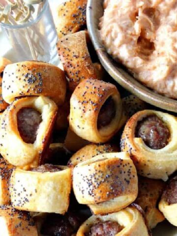 A pile of Bratwurst Bite Appetizers on a plate with poppy seeds on top.