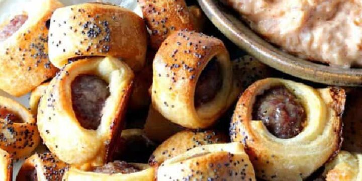 A pile of Bratwurst Bite Appetizers on a plate with poppy seeds on top.