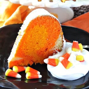 A colorful slice of Candy Corn Pound Cake on a black plate.