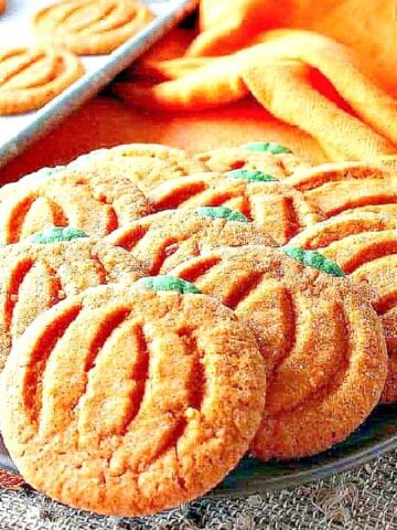 Orange and green Pumpkin Shaped Sugar Cookies on a platter.