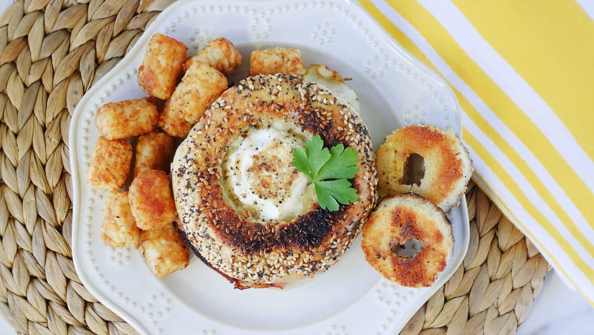 An overhead photo of an Egg in the Bagel Hole Breakfast Sandwich on a white plate.