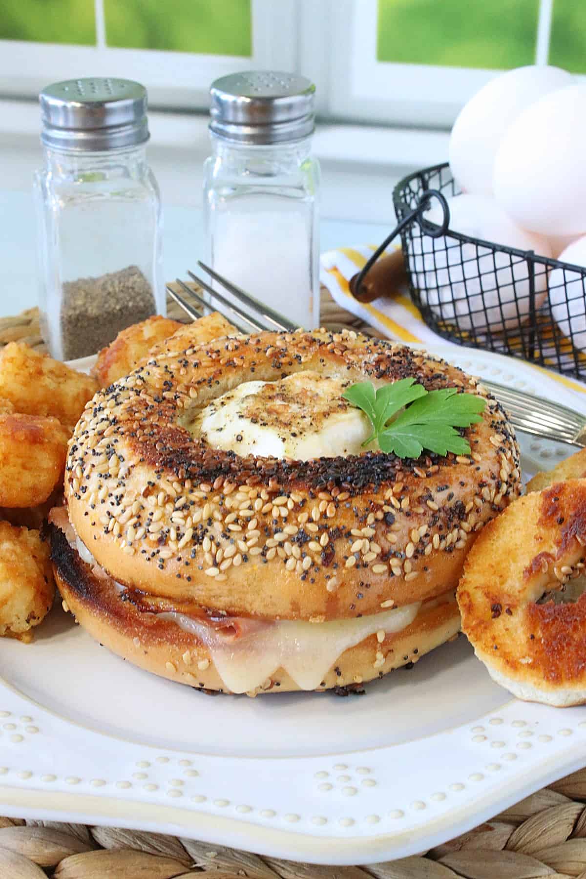 An Egg in the Hole Breakfast Sandwich on a plate with tater tots.