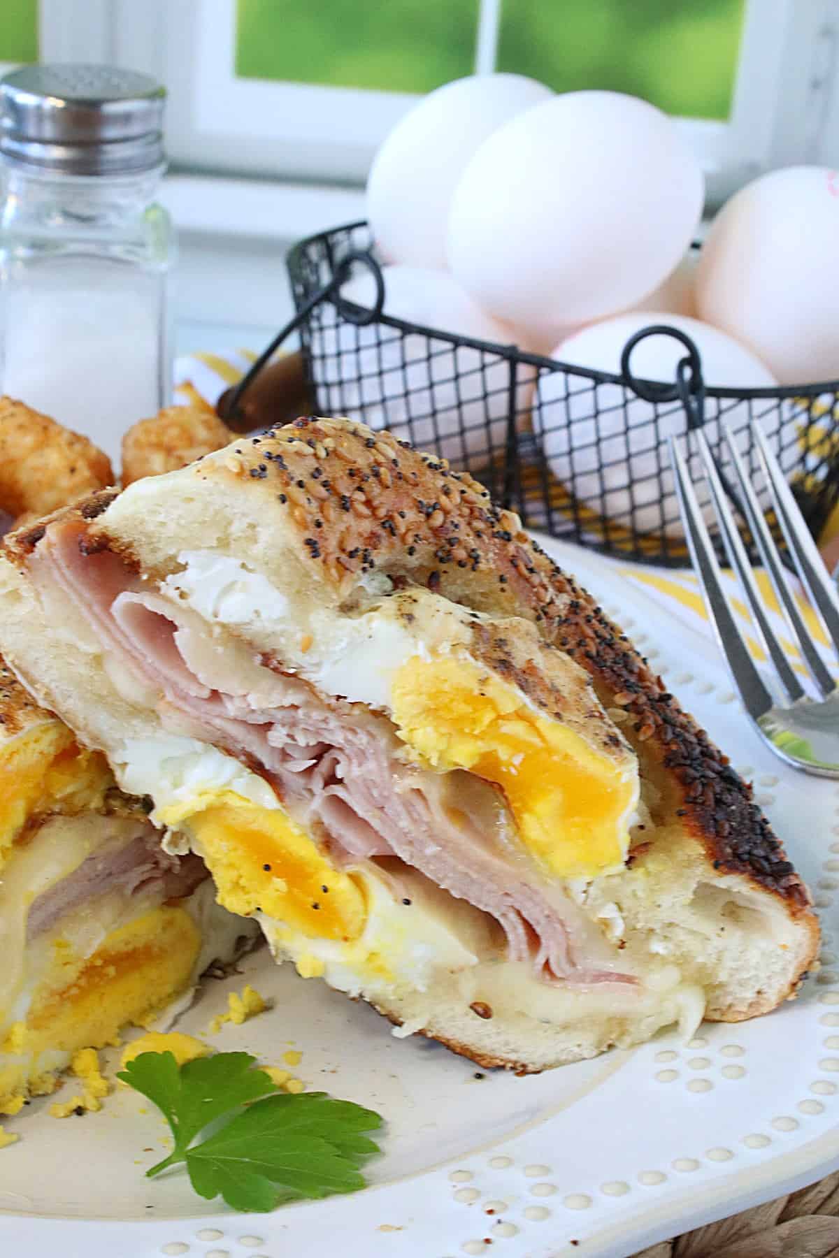 An Egg in the Bagel Hole Breakfast sandwich that's been cut in half.