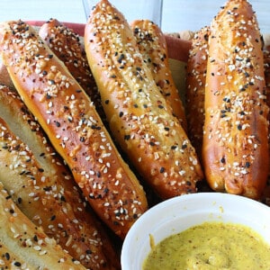 Soft Pretzel Rods sprinkled with everything seasoning along with a dish of mustard.