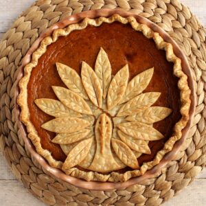 An adorable Turkey Crust Pumpkin Pie on a rattan placemat.