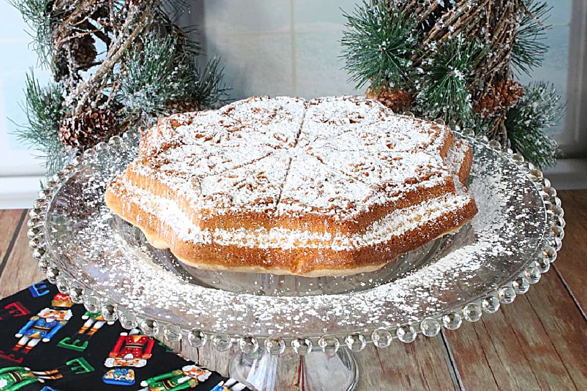 A snowflake-shaped Anise Cookie Bars cookie on a glass plate.