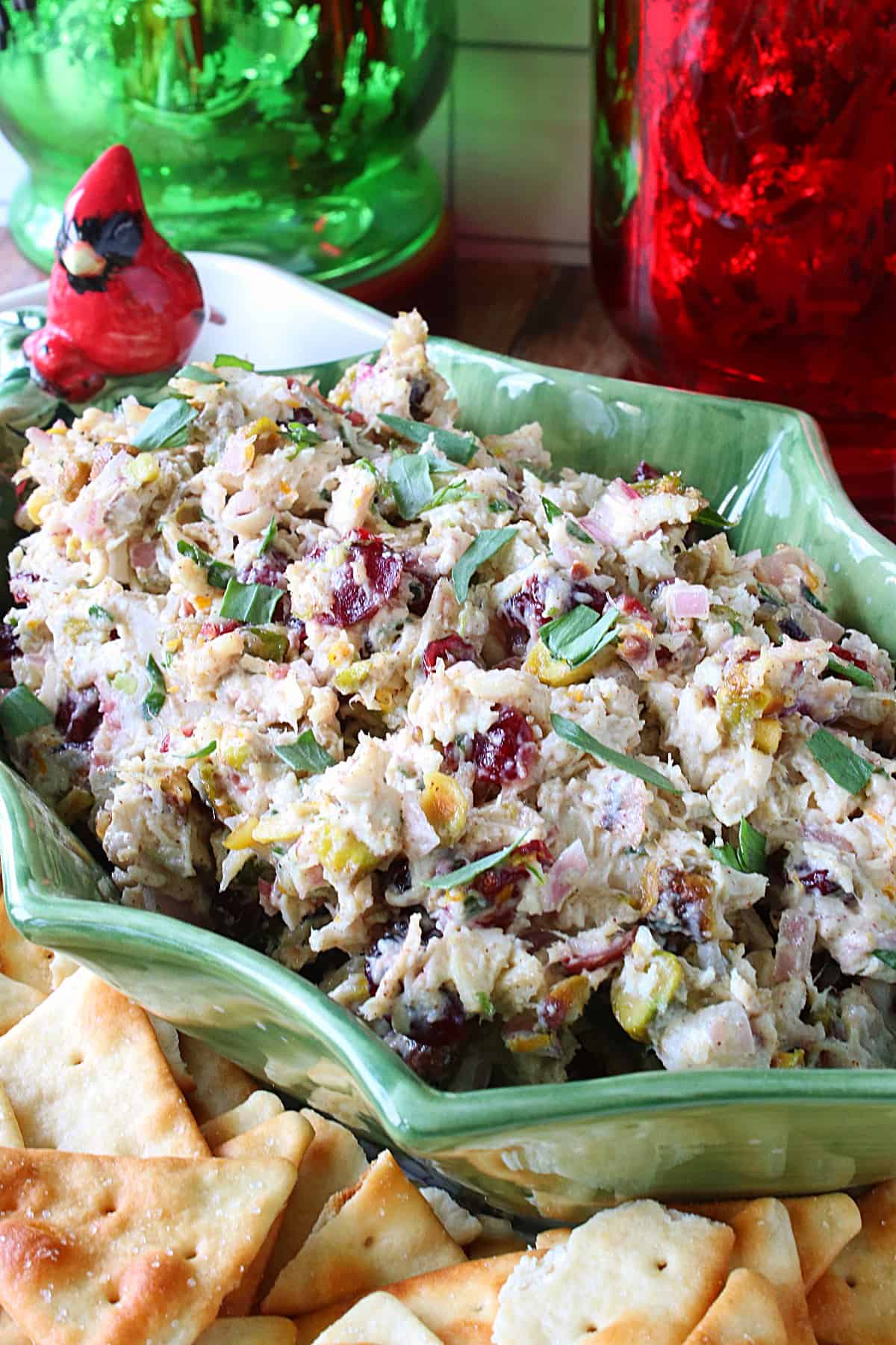 A festive Christmas Chicken Salad in a holly berry bowl with a cardinal.