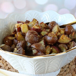 A pretty white bowl filled with Roasted Potatoes with Onion and Parmesan.