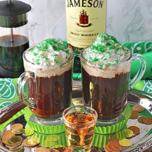 Two mugs of Traditional Irish Coffee on a silver tray with a shot of whiskey in the center.