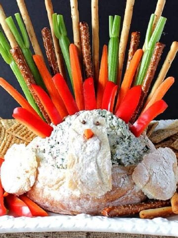 Colorful Turkey Bread Bowl Appetizer with Spinach Dip and vegetable feathers.