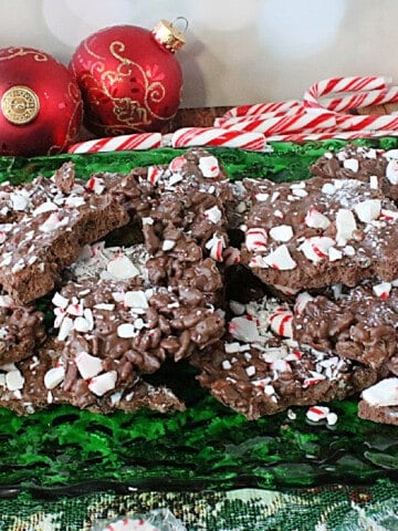 A pile of Cocoa Krispies Peppermint Bark candy on a green glass platter.