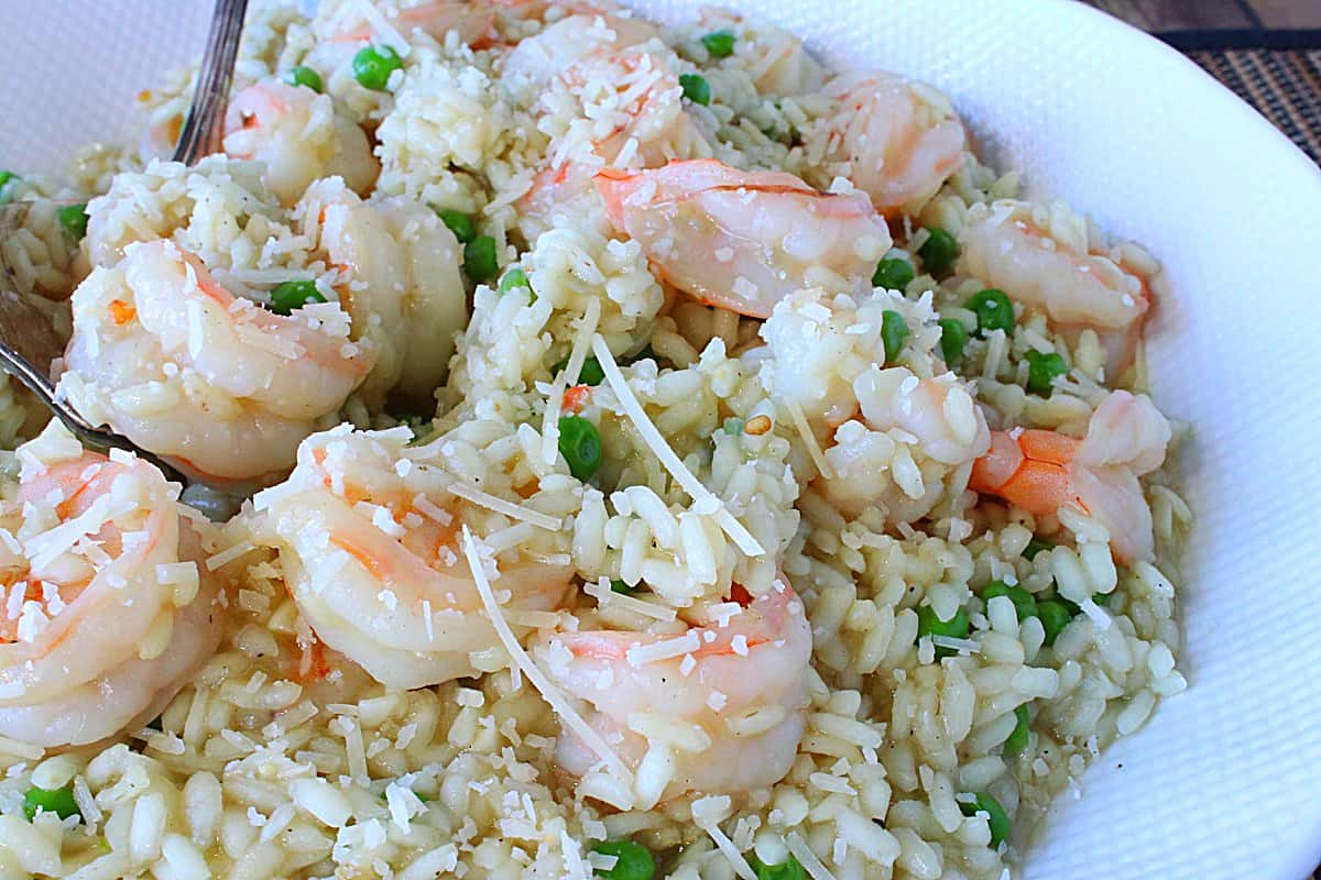A creamy bowl of Shrimp Scampi Risotto with grated Parmesan and Peas.