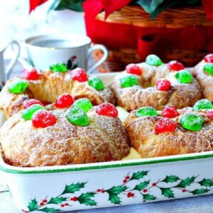 A pretty Christmas baking dish with holly and berries filled with Eggnog Pastry Cream Croissants.