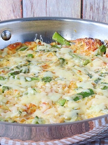 A silver skillet filled with a baked Asparagus and Gruyere Popover.