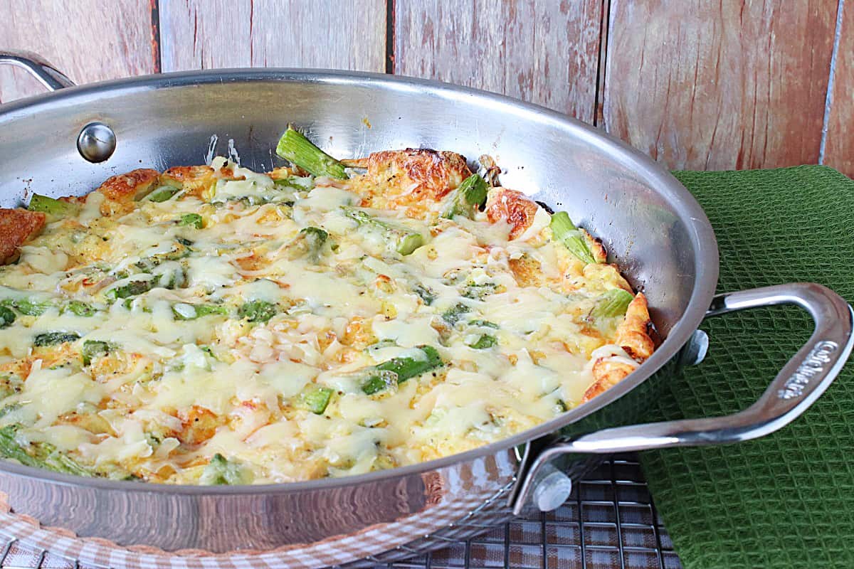 A silver skillet filled with a golden brown Asparagus and Gruyere Popover.