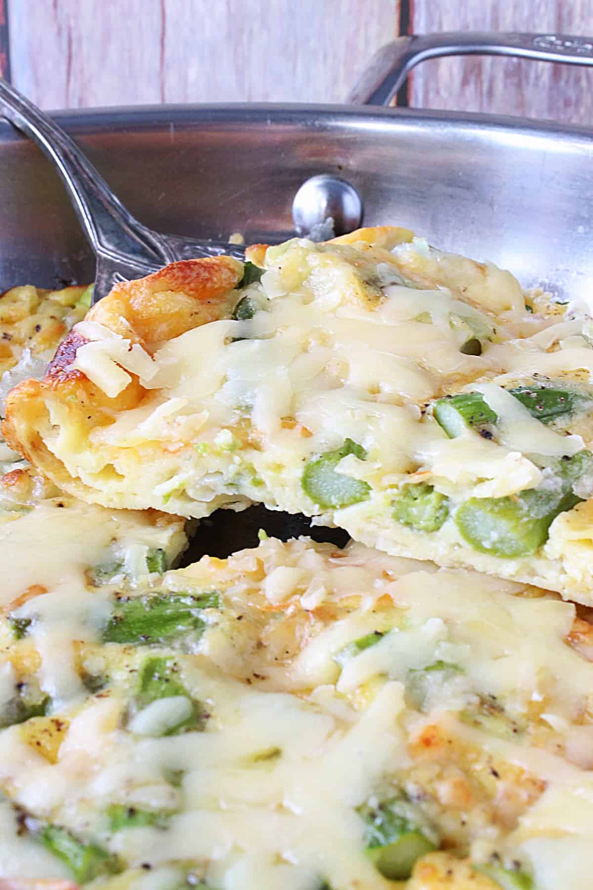 A closeup photo of a slice of Asparagus and Gruyere Popover on a silver server.