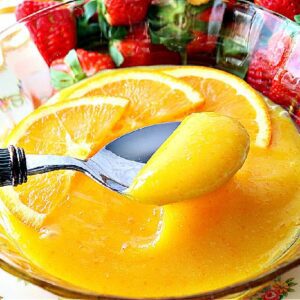 A spoon and bowl with Homemade Orange Curd.