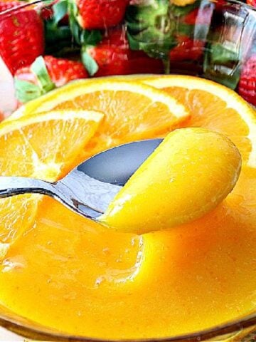 A spoon and bowl with Homemade Orange Curd.