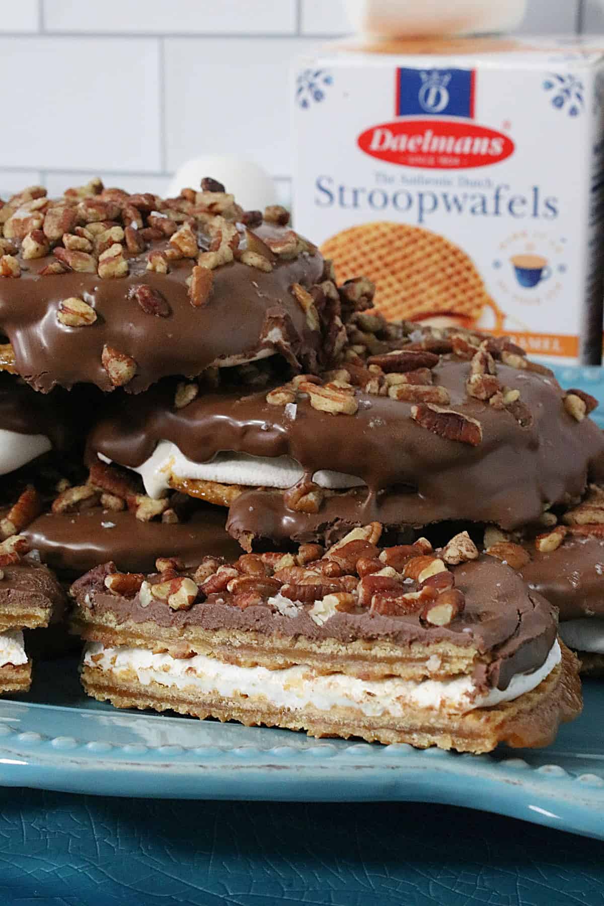 A decadent looking stack of S'mores Stroopwafel Sandwiches on a blue platter. 