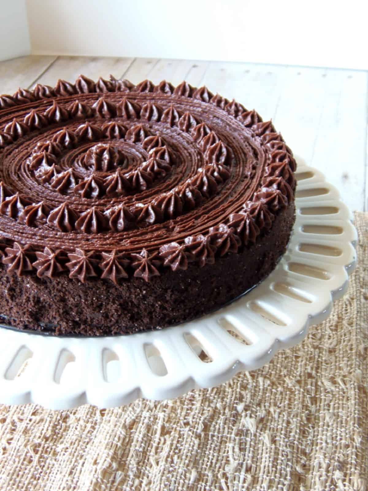 A pretty Chocolate Velvet Cake on a white cake stand.